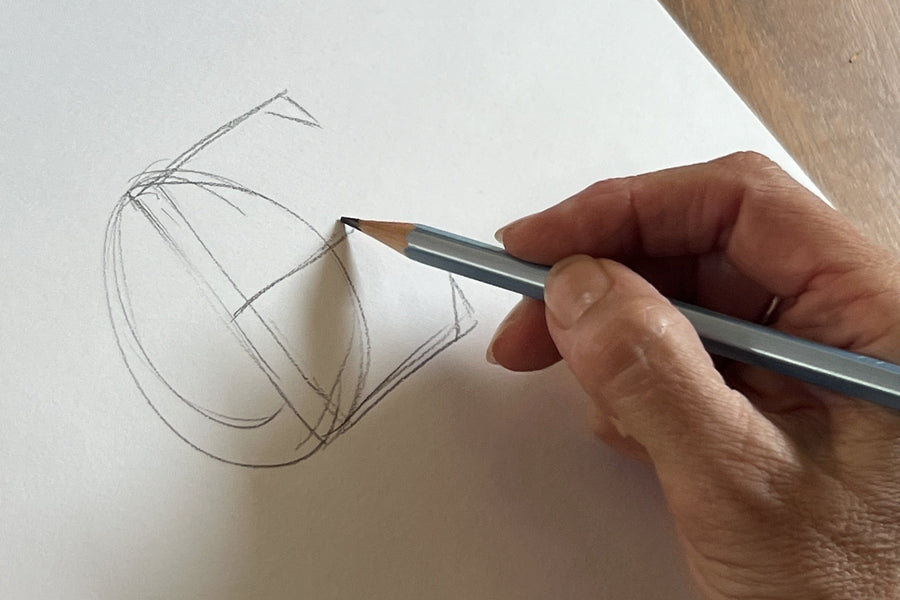 Patti's hand with a pencil, sketching the œ ligature in a notebook