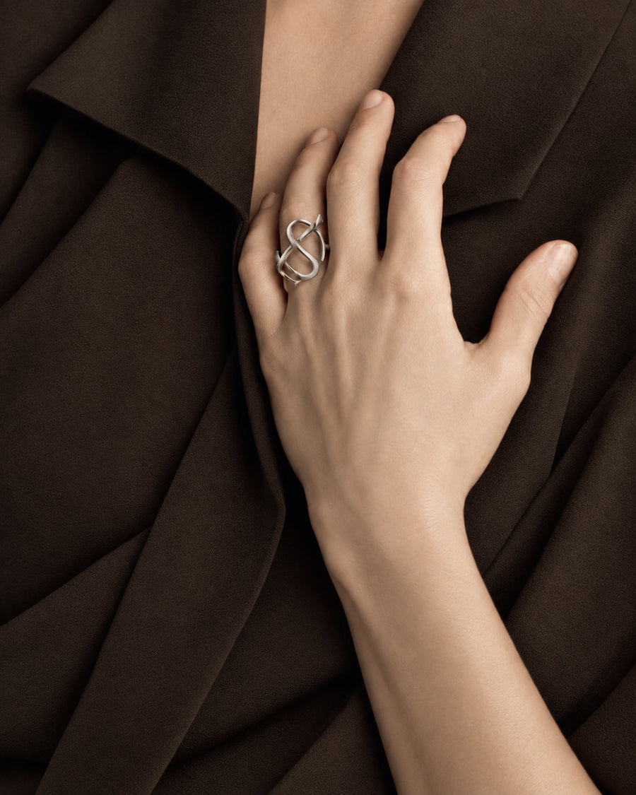 An Entwined earring and ring, worn