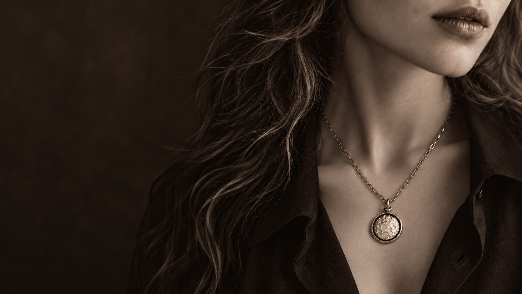 The Moon pendant worn at the collarbone, its face set to one night